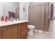 Well-lit bathroom featuring a single sink vanity, tile flooring, and shower with neutral shower curtain at 1407 Wheelwright Ct, Mesquite, NV 89034