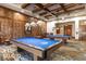 Bright billiard room with exposed beams, offering two billiard tables and wood wall paneling at 1407 Wheelwright Ct, Mesquite, NV 89034