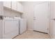 Functional laundry room with tile floors, shelving and modern, white washer and dryer at 1407 Wheelwright Ct, Mesquite, NV 89034