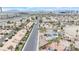 Aerial view of a residential area with palm trees, various roof types, and a distant view of the city skyline at 1462 Rawhide St, Las Vegas, NV 89119