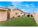 A spacious backyard features lush artificial turf, a stucco wall, and a covered patio area for outdoor entertaining at 1462 Rawhide St, Las Vegas, NV 89119