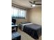 Bedroom with window, wood-look floors, ceiling fan, desk, and leather bench at 1462 Rawhide St, Las Vegas, NV 89119