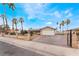 Well-maintained single-story home with palm trees and a large driveway, secured by an iron gate at 1462 Rawhide St, Las Vegas, NV 89119