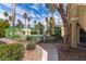 A community pool with a green fence is landscaped with desert foliage and palm trees at 1560 Jamielinn Ln # 101, Las Vegas, NV 89110