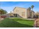 A landscaped backyard with artificial turf and a patio cover provides a peaceful outdoor retreat at 1903 Ginger Blossom Ave, North Las Vegas, NV 89031