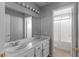 Neutral bathroom featuring double sink vanity, large mirror, and shower with sliding glass doors at 1903 Ginger Blossom Ave, North Las Vegas, NV 89031