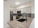 Well-lit kitchen with stainless steel appliances, mosaic backsplash, and granite countertops at 2251 Wigwam Pkwy # 314, Henderson, NV 89074