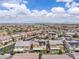 Detailed aerial view of a residential area showcasing homes with solar panels and landscaped backyards under a blue sky at 2833 Athena Hill Ct, Henderson, NV 89052