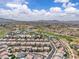 Beautiful aerial shot showcasing the neighborhood near a golf course with picturesque mountain views and clear blue skies at 2833 Athena Hill Ct, Henderson, NV 89052