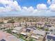 Wide aerial shot showcasing a large neighborhood, with neatly arranged homes, lush trees, and views of the distant city skyline at 2833 Athena Hill Ct, Henderson, NV 89052