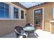 Comfortable outdoor sitting area with table and chairs adjacent to exterior home entry at 2833 Athena Hill Ct, Henderson, NV 89052