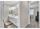 Bathroom featuring double sinks and view to a bedroom with carpeted floors at 2833 Athena Hill Ct, Henderson, NV 89052