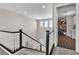This hallway features carpeted steps with a black and white banister and a laundry room at 2833 Athena Hill Ct, Henderson, NV 89052
