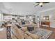 Open-concept living room with hardwood floors and a large sectional couch, adjacent to the kitchen at 2833 Athena Hill Ct, Henderson, NV 89052