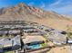 Aerial view of home showcasing a pool, desert landscape, and mountain backdrop at 3120 Greenscape Ln, Las Vegas, NV 89138