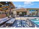 Covered outdoor kitchen, dining, and lounge area next to a pool at 3120 Greenscape Ln, Las Vegas, NV 89138