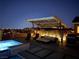 Relaxing backyard with pool, spa, shaded seating, grill, and city views at night at 3120 Greenscape Ln, Las Vegas, NV 89138