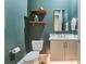 Modern powder room featuring floating shelves, a white vanity, and teal accent wall at 3120 Greenscape Ln, Las Vegas, NV 89138