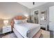 Bedroom features a plush bed with unique headboard, mirrored nightstand, and ensuite bathroom at 3120 Greenscape Ln, Las Vegas, NV 89138