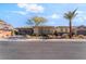 Front exterior showcasing desert landscaping, brick driveway, modern curb appeal, and attached garage at 3120 Greenscape Ln, Las Vegas, NV 89138