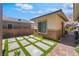 View of a modern home featuring a contemporary designed yard with artificial turf and paved stone at 3120 Greenscape Ln, Las Vegas, NV 89138