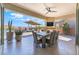 Covered outdoor dining area with pool view, fireplace, and desert landscaping at 3120 Greenscape Ln, Las Vegas, NV 89138