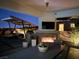 Outdoor covered patio features a fireplace, TV, ceiling fan, and dining set at 3120 Greenscape Ln, Las Vegas, NV 89138