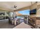 Outdoor covered patio with a fireplace, TV, ceiling fan, and mountain views at 3120 Greenscape Ln, Las Vegas, NV 89138