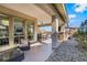 Covered patio with comfortable seating, ceiling fan, and stylish landscaping at 3120 Greenscape Ln, Las Vegas, NV 89138