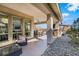 Covered patio with comfortable seating, ceiling fan, and stylish landscaping at 3120 Greenscape Ln, Las Vegas, NV 89138