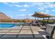 Backyard oasis featuring a modern pool, lounge area with shade, and desert landscaping at 3120 Greenscape Ln, Las Vegas, NV 89138