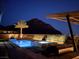 Backyard pool and spa at night with views of the mountains at 3120 Greenscape Ln, Las Vegas, NV 89138