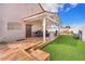 Inviting backyard featuring covered patio, grill, and well-manicured artificial turf at 3536 Golden Pedal St, Las Vegas, NV 89129