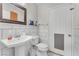 Compact bathroom with pedestal sink, toilet, tiled walls, and pet door at 3536 Golden Pedal St, Las Vegas, NV 89129