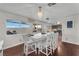 Bright dining area with a modern chandelier, large windows, and hardwood flooring at 3536 Golden Pedal St, Las Vegas, NV 89129