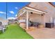 Spacious backyard with covered patio featuring built-in grill, artificial grass and patio furniture at 3536 Golden Pedal St, Las Vegas, NV 89129