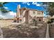 Back of a tan two-story home surrounded by gravel landscaping, featuring palm trees and a block fence at 3789 Gershon Ct, Las Vegas, NV 89121
