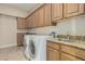Well-equipped laundry room with granite countertops, ample cabinet space, and modern washer and dryer at 3789 Gershon Ct, Las Vegas, NV 89121
