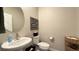 This powder room features a round mirror, patterned artwork and a basket for storage at 4181 Nopal Serrano Ave, Las Vegas, NV 89141