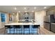 Well-appointed kitchen featuring a large island with bar stools, stainless steel appliances, and stylish cabinets at 4181 Nopal Serrano Ave, Las Vegas, NV 89141