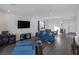 Bright living room with blue sofa set, gray accent rug, and large-screen television at 4315 E Cactus Canyon Dr, Pahrump, NV 89061