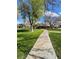 Manicured green space with mature trees and a paved walkway through the community at 5083 Village Dr, Las Vegas, NV 89142