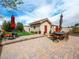 Paver patio featuring outdoor dining set, putting green, mature trees and lovely, sunny landscaping at 5340 N Campbell Rd, Las Vegas, NV 89149