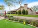 Lush backyard with putting green, mature trees, green lawn and patio, creating a serene outdoor space at 5340 N Campbell Rd, Las Vegas, NV 89149