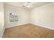 Bedroom with tile floors, ceiling fan, baseboard trim, and view of the front yard at 5340 N Campbell Rd, Las Vegas, NV 89149