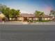 Charming single-story home with a tile roof, well-manicured landscaping, and mature trees at 5340 N Campbell Rd, Las Vegas, NV 89149