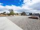 View of a gravel lot with concrete pad in the foreground and other structures and landscaping in the background at 5340 N Campbell Rd, Las Vegas, NV 89149