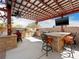 Covered outdoor kitchen has granite countertops, stainless steel appliances, and bar seating area at 5340 N Campbell Rd, Las Vegas, NV 89149