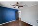 Cozy bedroom with a dark blue accent wall and wood-look flooring at 6709 Rancho Santa Fe Dr, Las Vegas, NV 89130