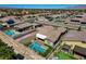 A pristine backyard features a pool, in-ground spa, artificial grass, fire pit, and nearby palm trees at 7119 Falabella Ridge Ave, Las Vegas, NV 89131